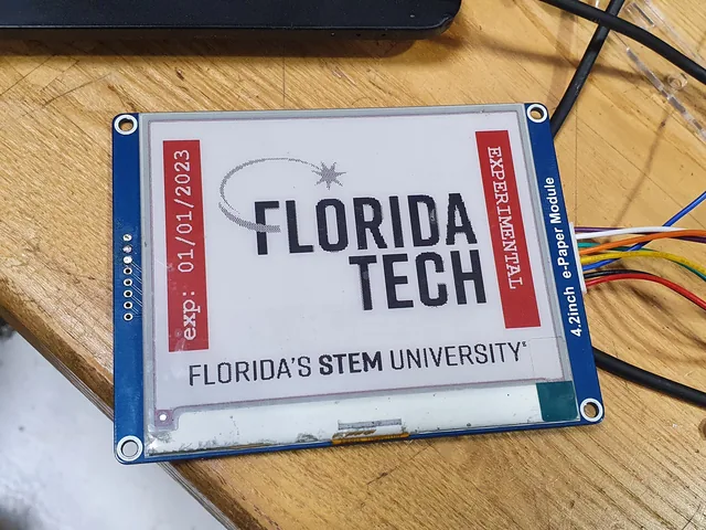A 4.2-inch e-paper module showing an expired Florida Tech parking decal marked experimental.