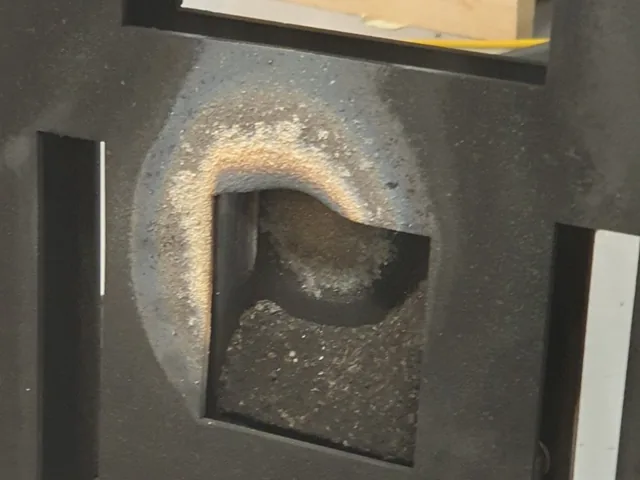 Close-up of the stand&rsquo;s heat-shield tile after a firing, scorched in a ring around the opening.