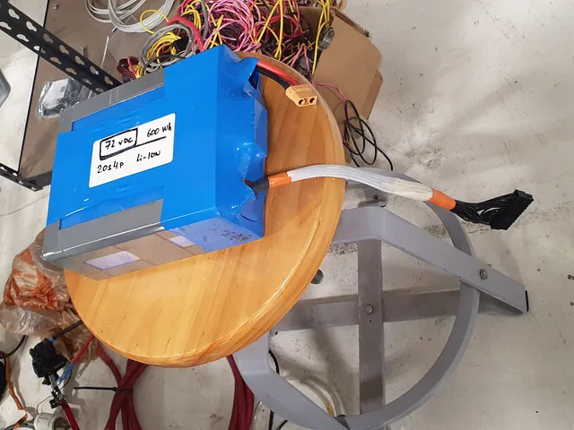 A blue-wrapped battery pack labeled 72 VDC, 600 Wh, 20S4P lithium-ion, with an XT60 connector and a braided balance lead.